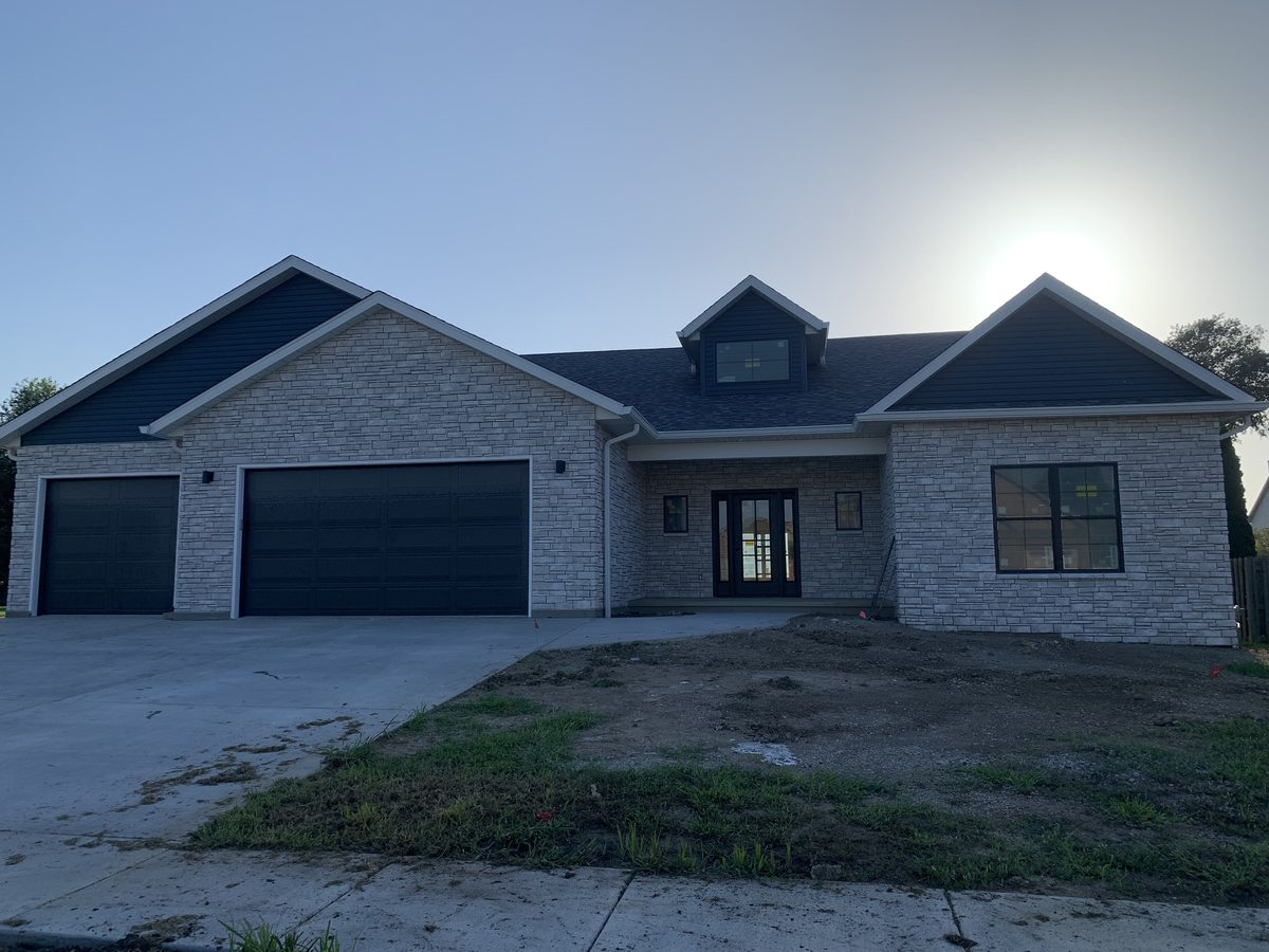 The finished home at 121 Ramblewood Rd in Chatham, Illinois — stone facade with a dark shingle roof, built by Block Built Construction